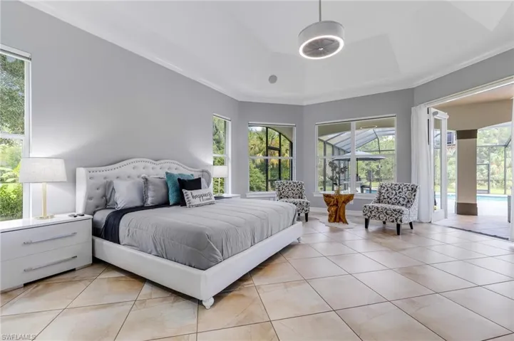 Bedroom featuring ornamental molding, access to exterior, multiple windows, and light tile patterned floors