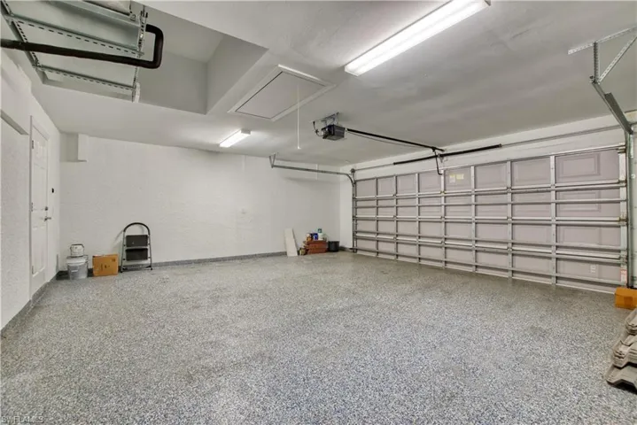 Garage with a textured wall and a garage door opener