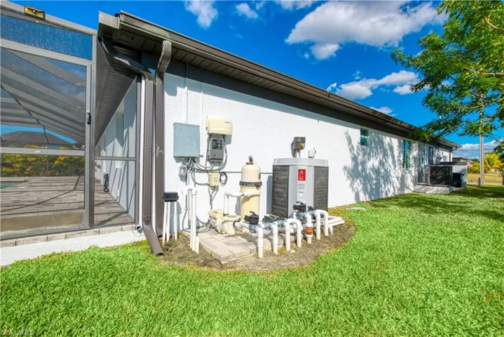 View of side of home featuring a sunroom, stucco siding, and a lawn