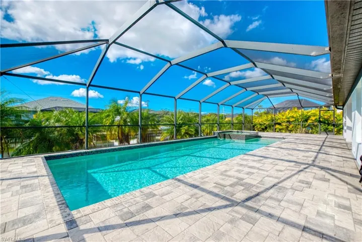 Integrated pool / spa featuring a sunroom, glass enclosure, and a patio area