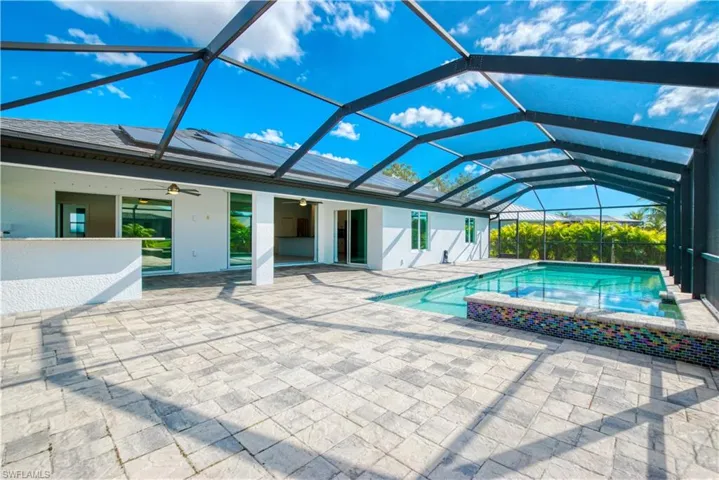 Relaxing pool / spa with a sunroom, glass enclosure, and a patio area