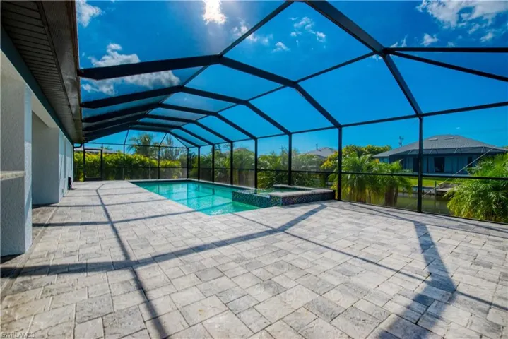Integrated pool / spa with a sunroom, a patio, and glass enclosure
