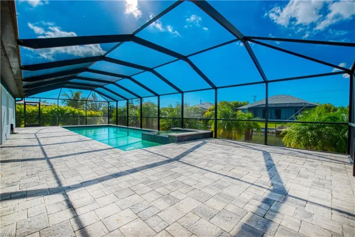 Combined pool / hot tub with a sunroom, a patio, and a lanai