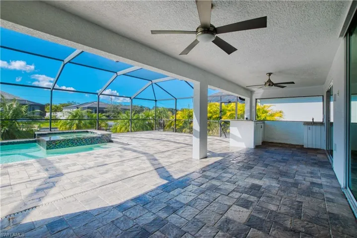 View of patio with a pool with connected hot tub, a sunroom, a lanai, and ceiling fan