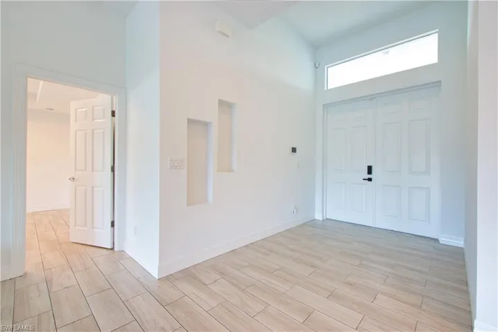 Entryway featuring a high ceiling and wood finish floors