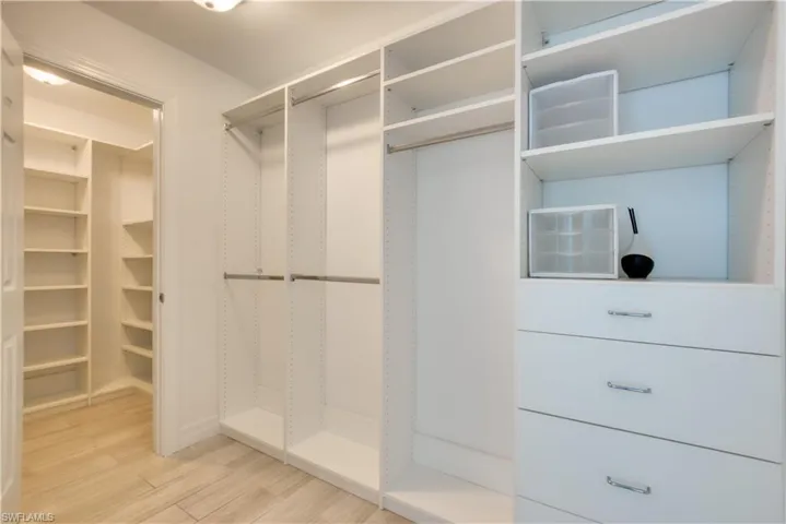 Walk in closet with light wood-type flooring