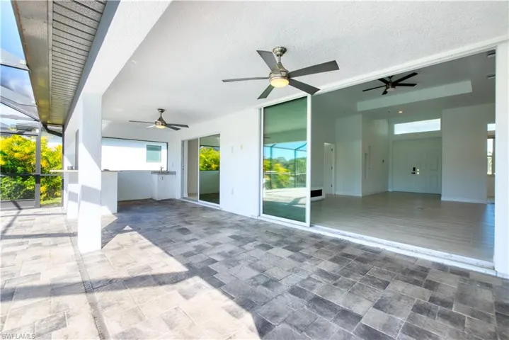 View of patio featuring ceiling fan and a lanai
