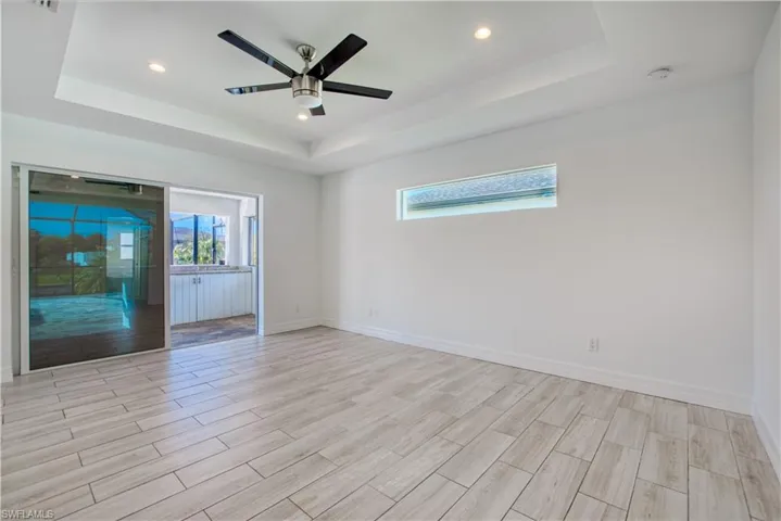 Unfurnished room featuring a ceiling fan, wood tiled floors, recessed lighting, and a raised ceiling