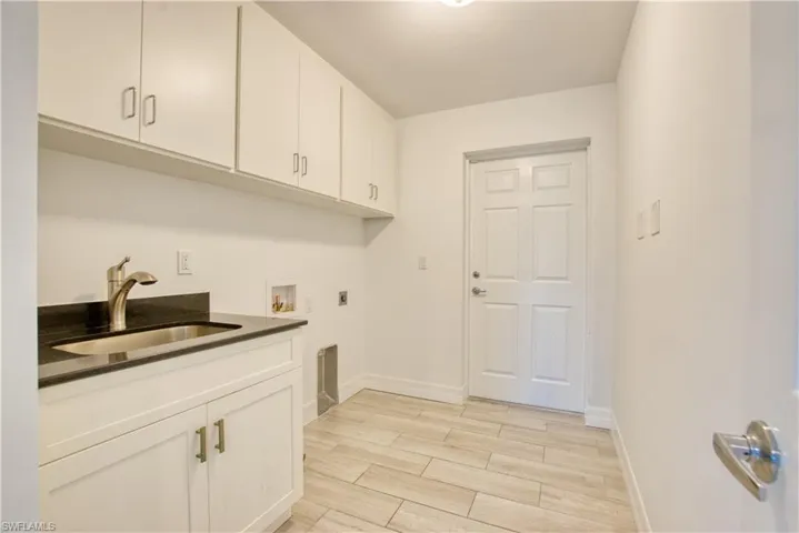Laundry room with cabinet space, wood tiled floors, and hookup for a washing machine