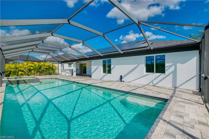 Integrated pool / hot tub with a sunroom, a patio, and a lanai