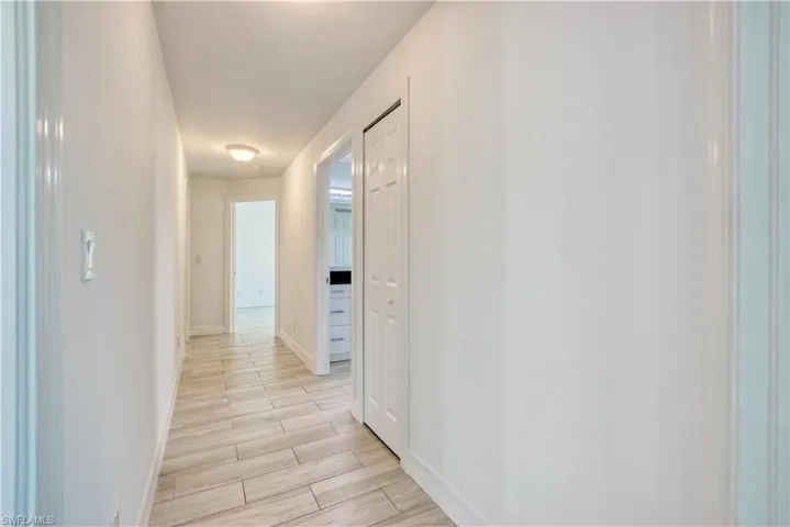 Hallway with wood tiled floors and baseboards