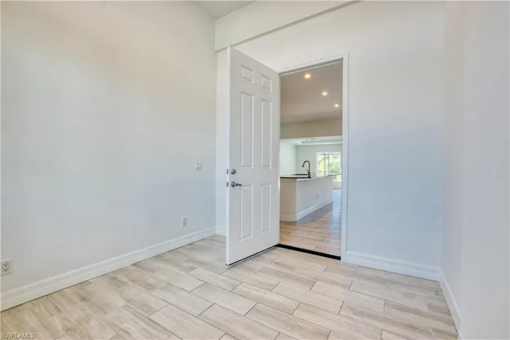 Empty room with wood tiled floors and recessed lighting