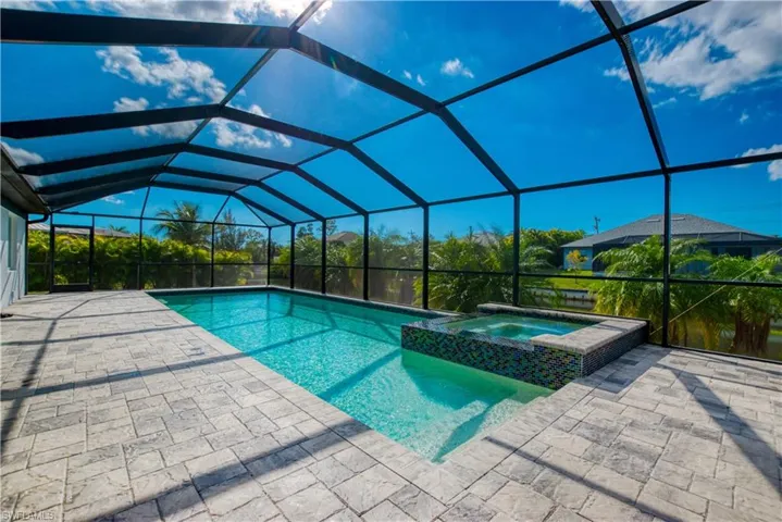 Integrated pool / spa with a sunroom, glass enclosure, and a patio area