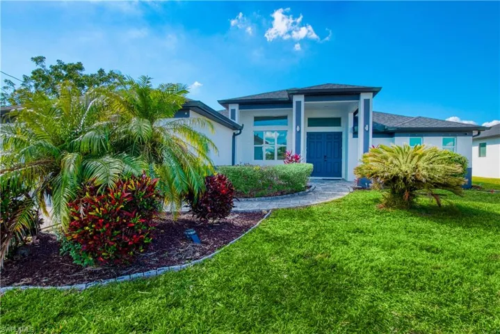 View of front of house with a front yard and stucco siding
