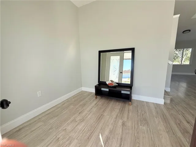 Empty room featuring baseboards and light wood-style flooring