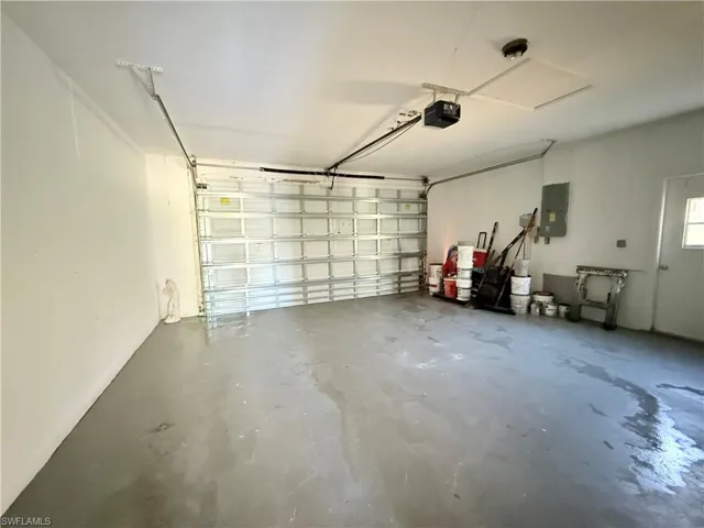 Garage featuring a garage door opener and electric panel