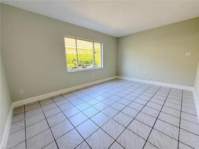 Spare room with baseboards and light tile patterned floors