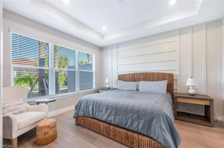 Bedroom featuring light hardwood / wood-style floors and a tray ceiling