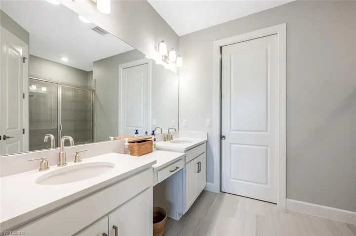 Bathroom featuring vanity and a shower with door