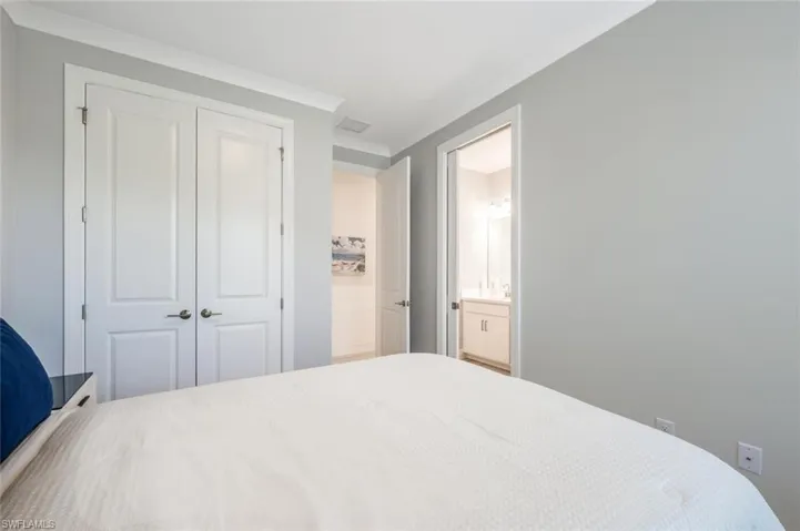 Bedroom with ensuite bathroom, a closet, and crown molding