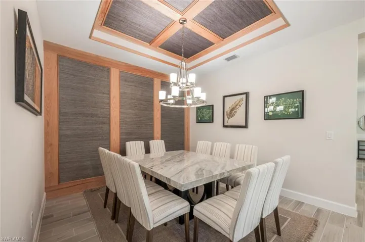 Dining room featuring crown molding, an inviting chandelier, coffered ceiling, and wooden ceiling