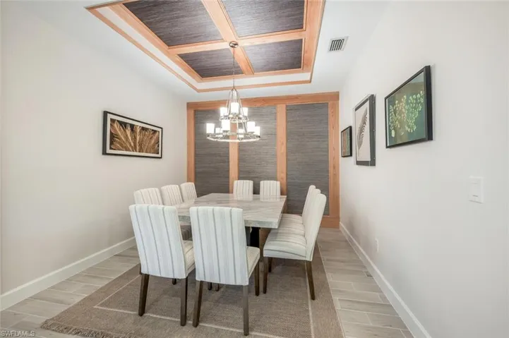 Dining room with a chandelier and coffered ceiling