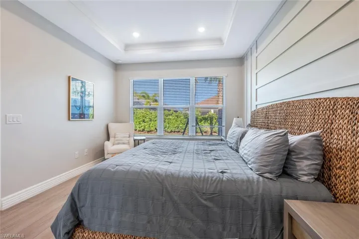 Bedroom with light hardwood / wood-style flooring and a tray ceiling