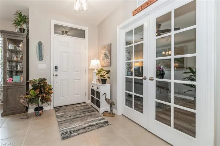 Tiled entryway featuring french doors