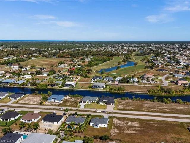 Aerial perspective of suburban area featuring a nearby body of water