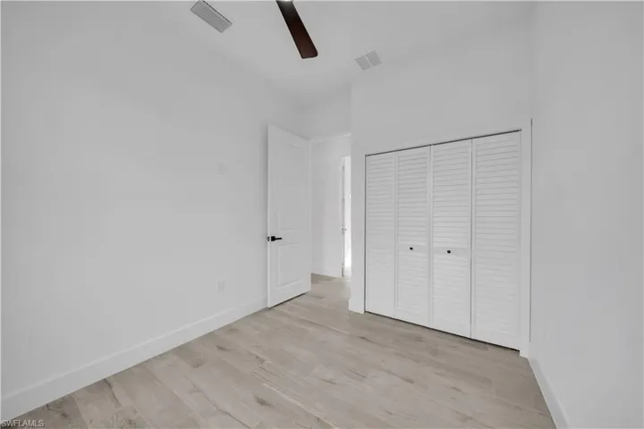 Unfurnished bedroom featuring light wood-type flooring, a closet, and ceiling fan