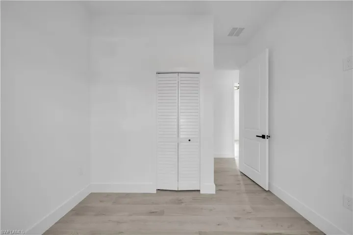 Unfurnished bedroom featuring light wood finished floors and a closet