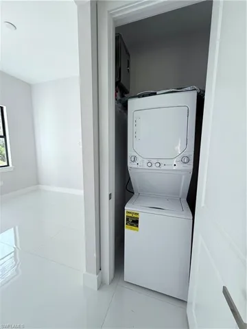 Dedicated laundry closet featuring a white stacked washer and dryer unit