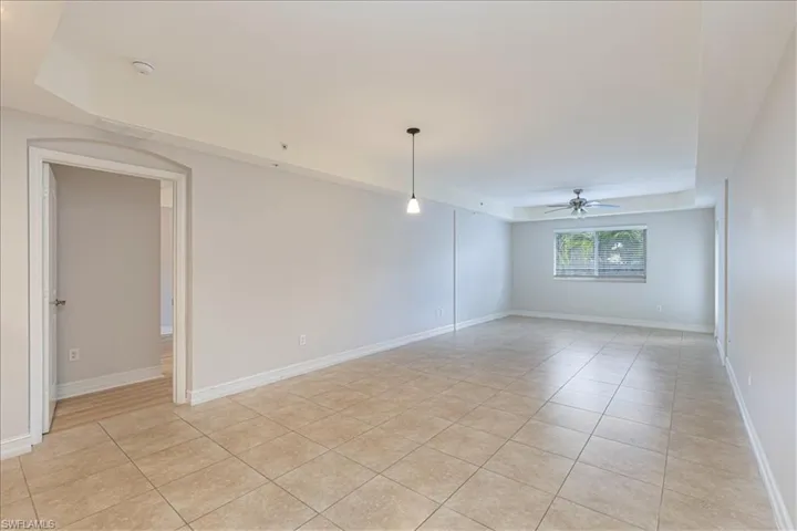 Empty room featuring light tile patterned floors and a ceiling fan
