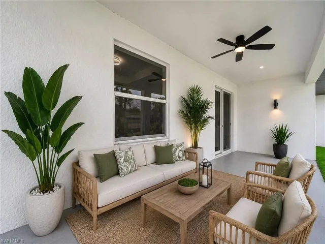 Virtually Staged patio images: Covered outdoor patio featuring a ceiling fan, recessed lighting, and wall-mounted sconces and plants.