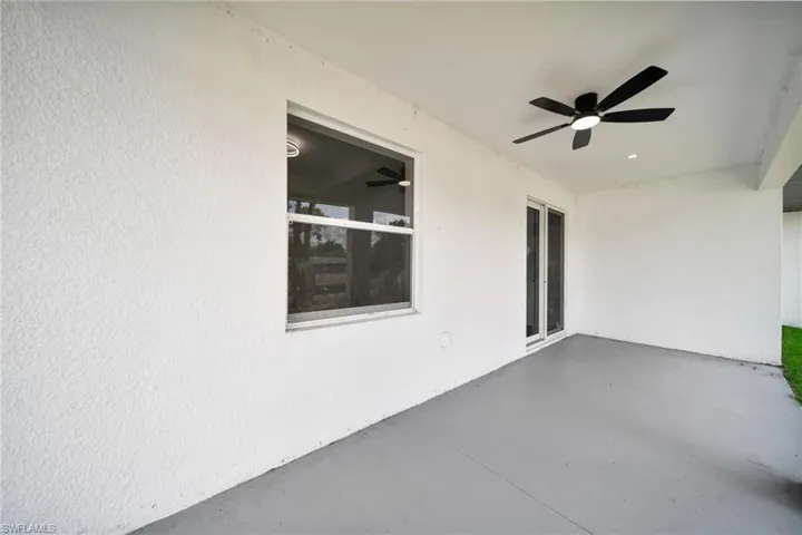 Spacious covered patio featuring a ceiling fan with integrated lighting, recessed lighting, and a white stucco exterior