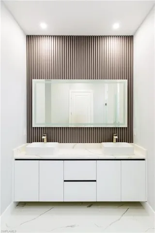 Bathroom with double vanity, recessed lighting, a sink, and marble finish floor