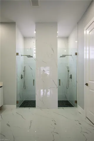 Full bath featuring visible vents, marble finish floor, a marble finish shower, and baseboards