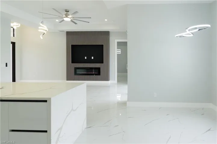 Kitchen featuring ceiling fan, light stone countertops, baseboards, marble finish floor, and recessed lighting