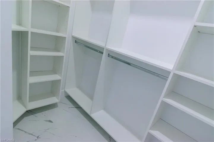 Walk in closet with marble finish floor