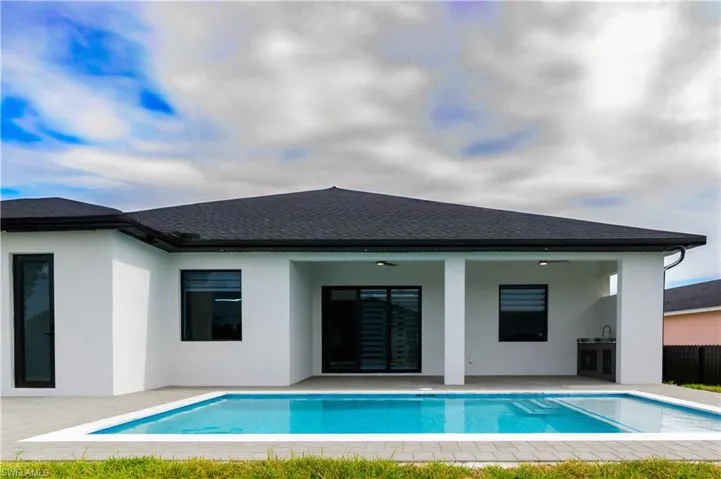 Rear view of property with stucco siding, a fenced in pool, a shingled roof, a ceiling fan, and a patio area