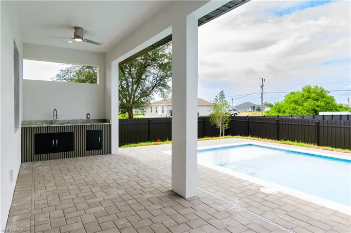 View of pool with ceiling fan, a fenced in pool, a fenced backyard, and a patio area