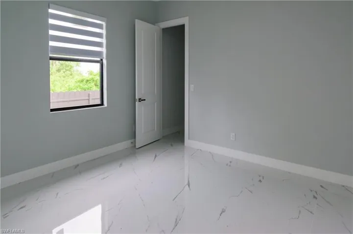 Empty room featuring baseboards and marble finish floor