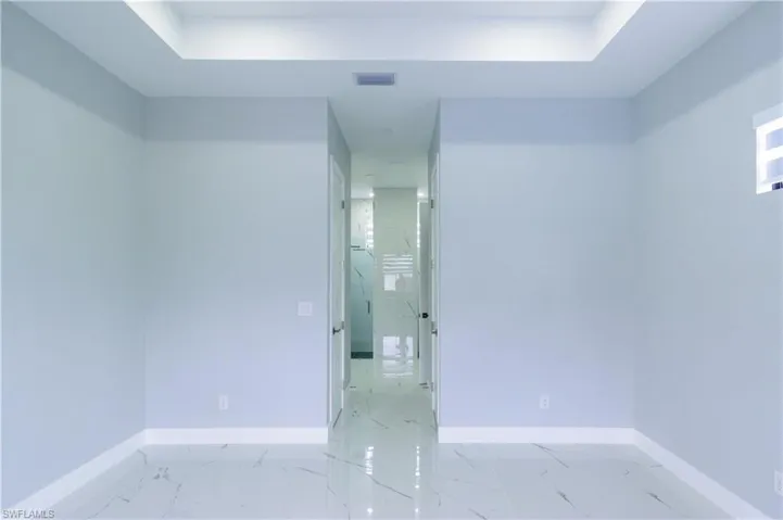 Empty room featuring baseboards, marble finish floor, and visible vents
