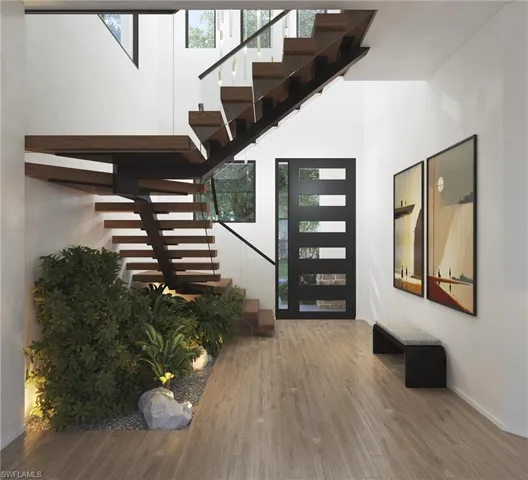 This is a rendering. Foyer with wood finished floors, stairway, and a high ceiling
