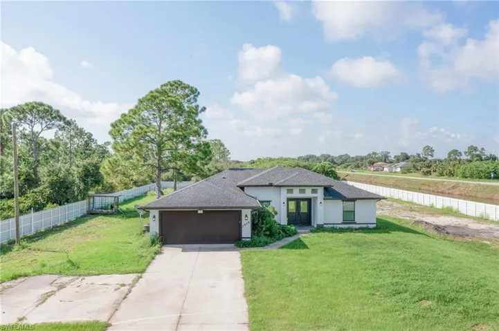 View of front facade with a garage and a front lawn