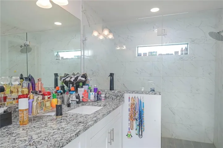 Bathroom featuring a tile shower and vanity