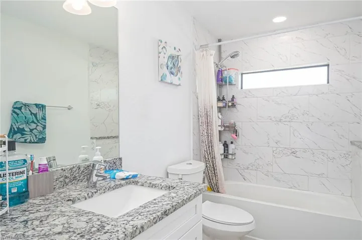 Full bathroom featuring vanity, shower / tub combo, and toilet