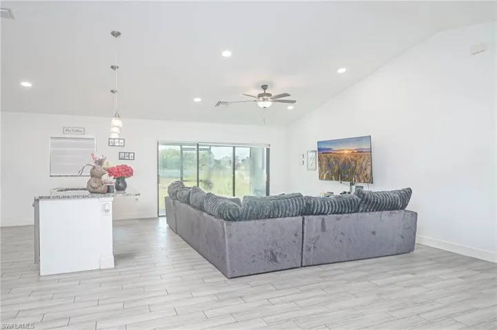 Living room featuring ceiling fan, light hardwood / wood-style floors, and high vaulted ceiling