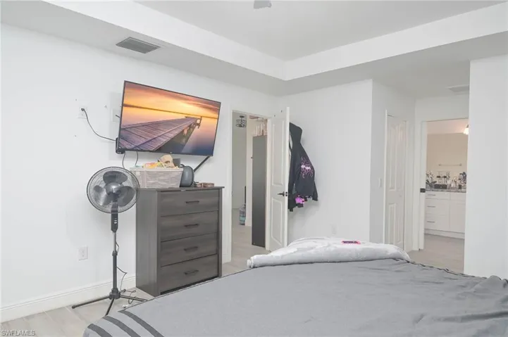 Bedroom with light hardwood / wood-style flooring and connected bathroom