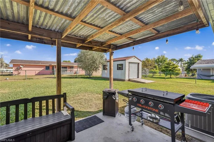 Fenced backyard featuring a patio area and an outdoor structure